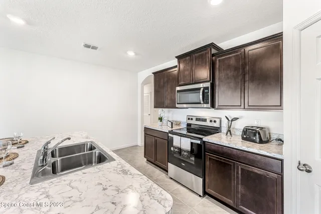 a kitchen with a sink stove and oven