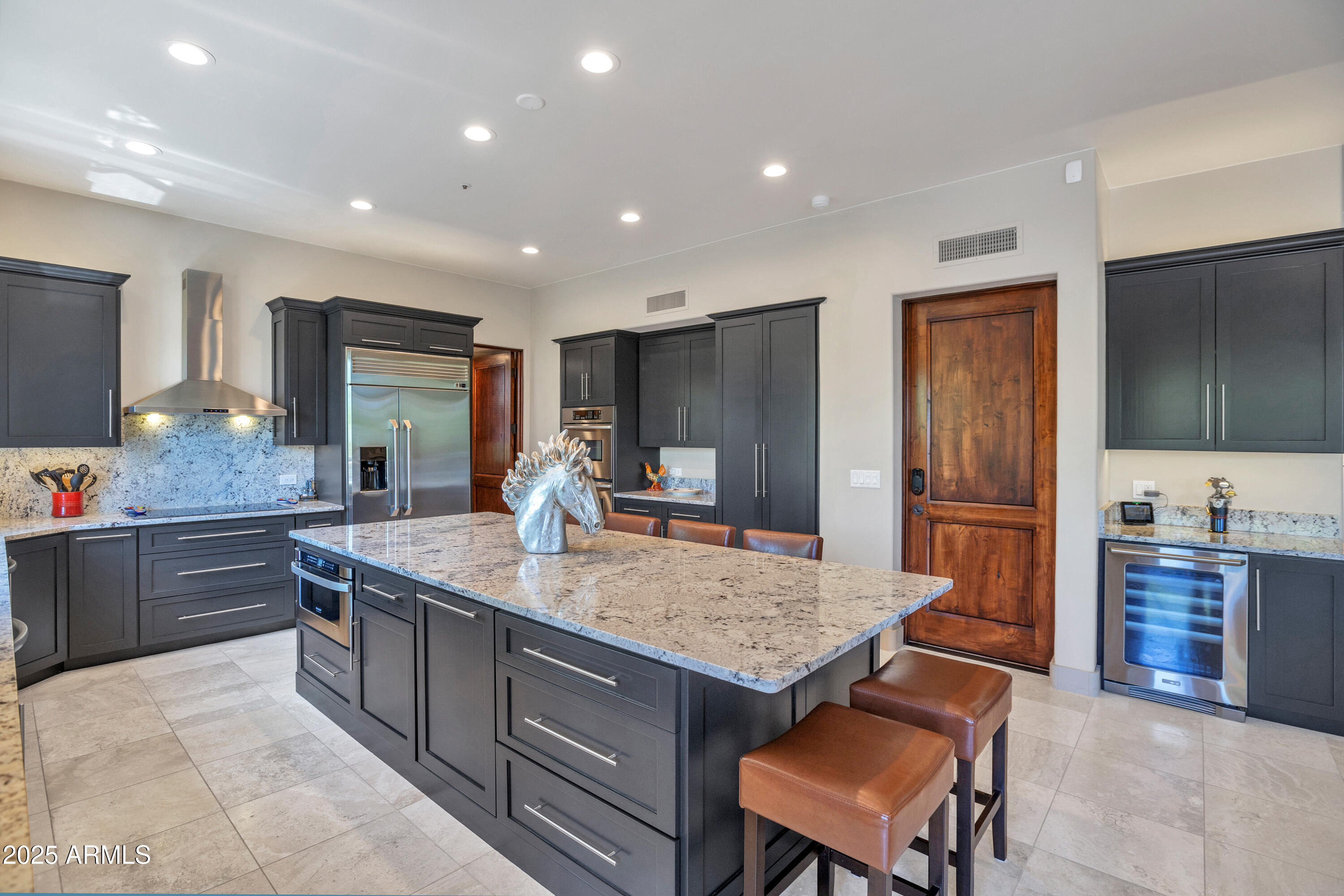 10040 East Happy Valley Road, Unit 268 Scottsdale, AZ 85255 - Photo 14 of 40 a kitchen with kitchen island granite countertop wooden cabinets and a refrigerator