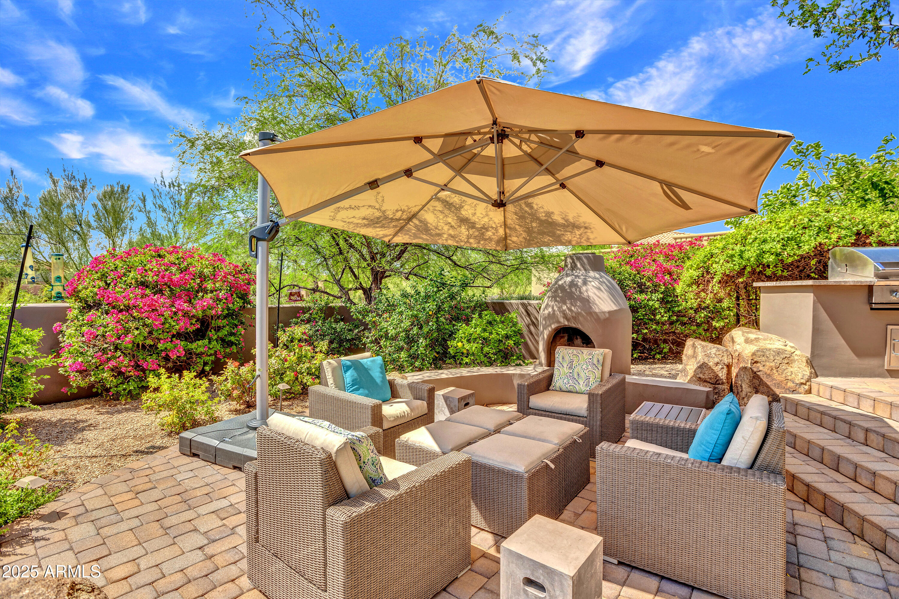 10040 East Happy Valley Road, Unit 268 Scottsdale, AZ 85255 - Photo 32 of 40 a view of a patio with couches table and chairs under an umbrella with a small yard