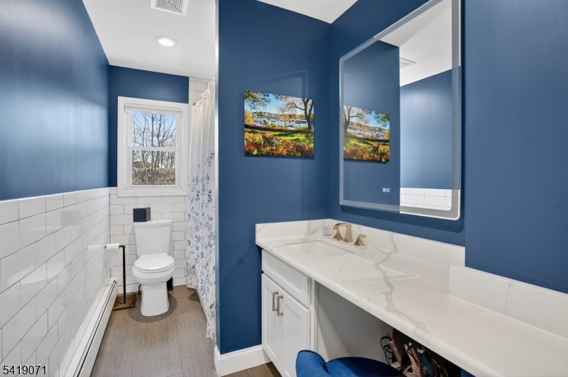 116 Star Lake Road Bloomingdale, NJ 07403 - Photo 6 of 24 a bathroom with a sink a toilet and mirror
