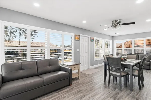 a kitchen with stainless steel appliances granite countertop a table chairs refrigerator and sink
