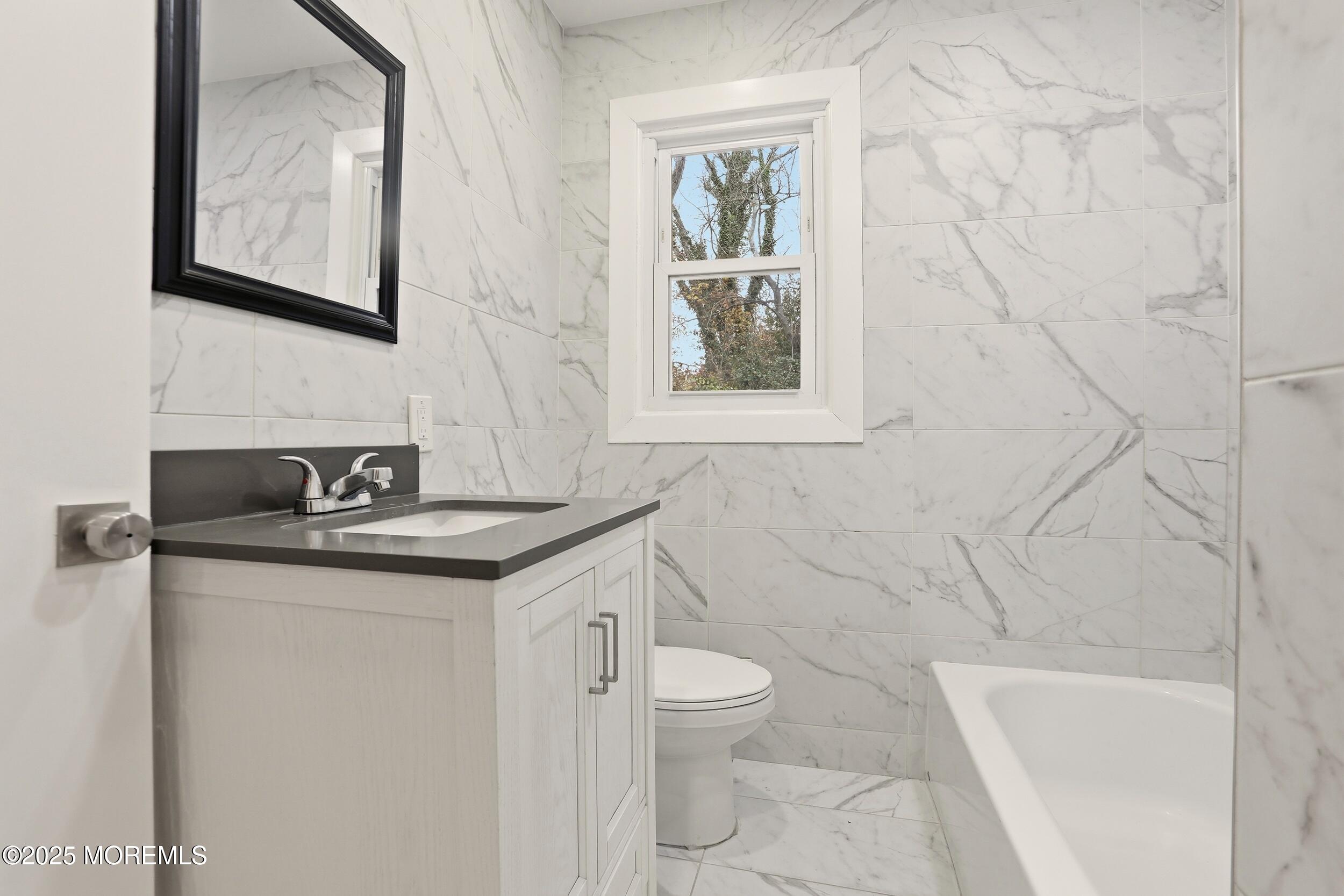 2930 Highway 9 Howell, NJ 07731 - Photo 21 of 30 a bathroom with a granite countertop sink toilet and a bathtub