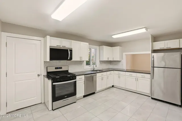 a kitchen with granite countertop white cabinets and white appliances