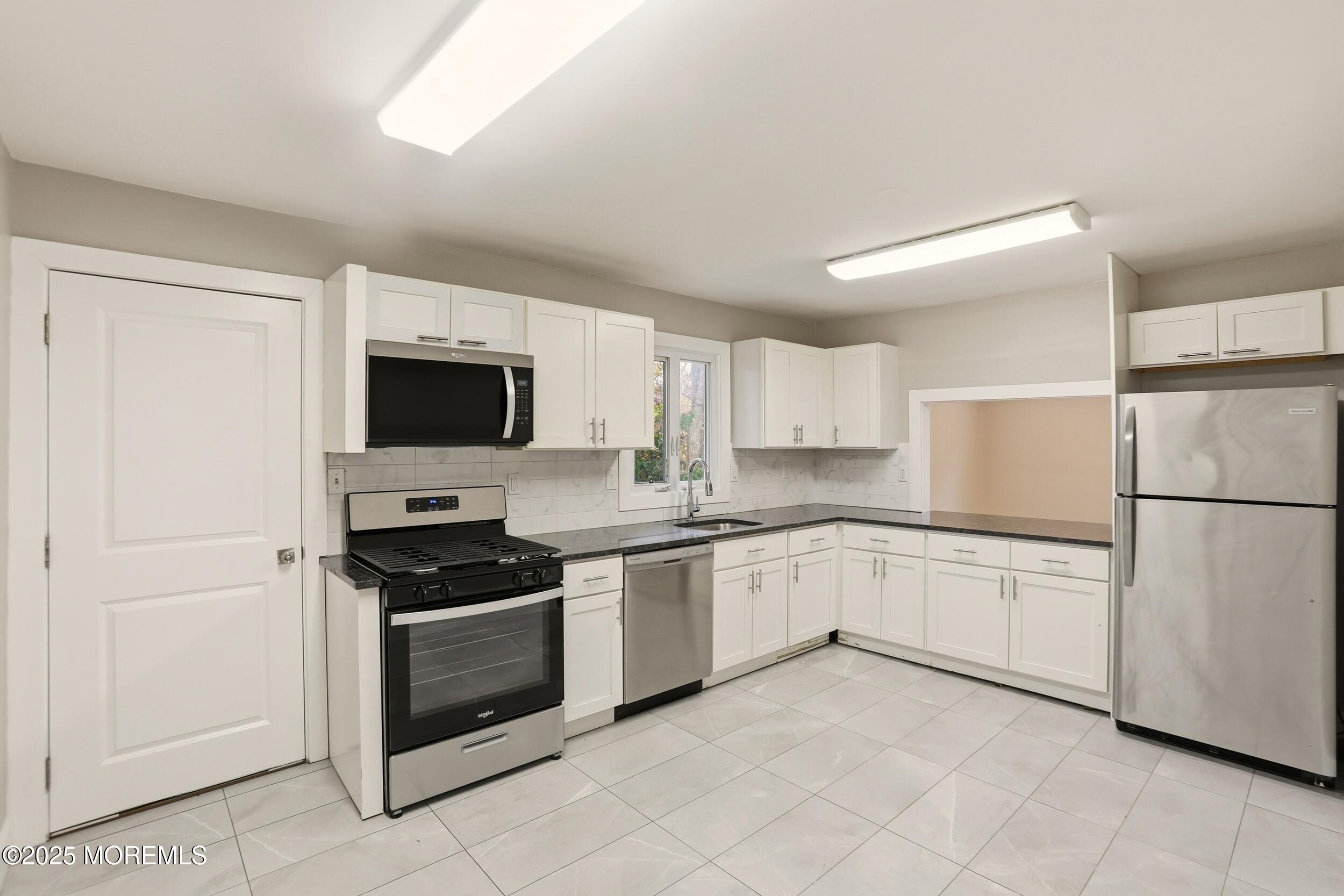 2930 Highway 9 Howell, NJ 07731 - Photo 6 of 30 a kitchen with granite countertop white cabinets and white appliances