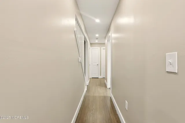 a view of a hallway with wooden floor