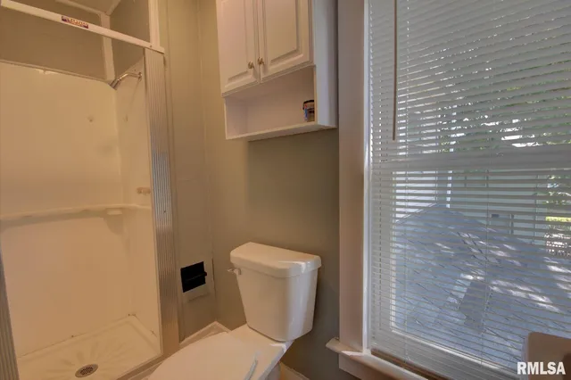 a bathroom with a toilet and a shower