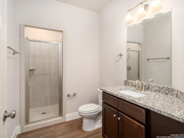 a bathroom with a granite countertop sink toilet and shower