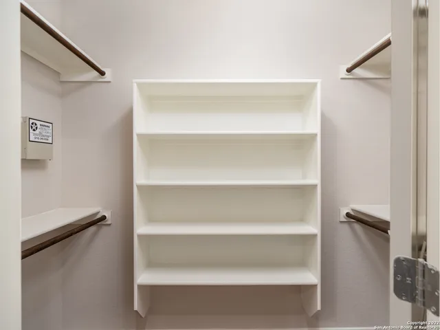 a view of walk in closet with empty racks