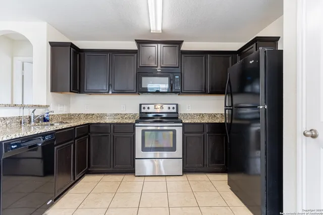 a kitchen with a refrigerator stove top oven and cabinets