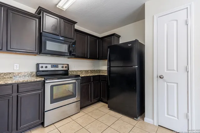 a kitchen with stainless steel appliances granite countertop a refrigerator and a sink