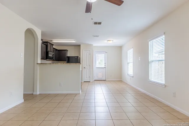 an empty room with windows and cabinet