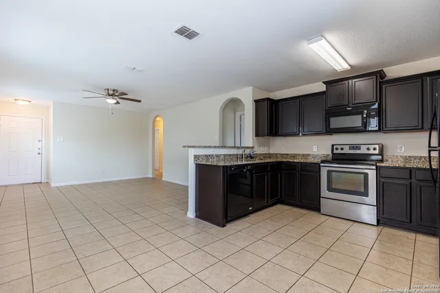 a kitchen with stainless steel appliances granite countertop a refrigerator and a stove top oven