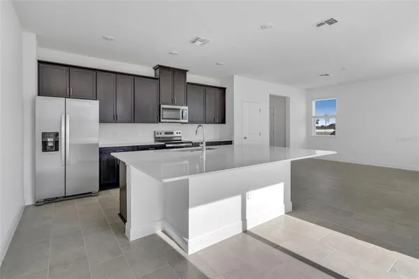 a kitchen with stainless steel appliances a refrigerator sink and cabinets