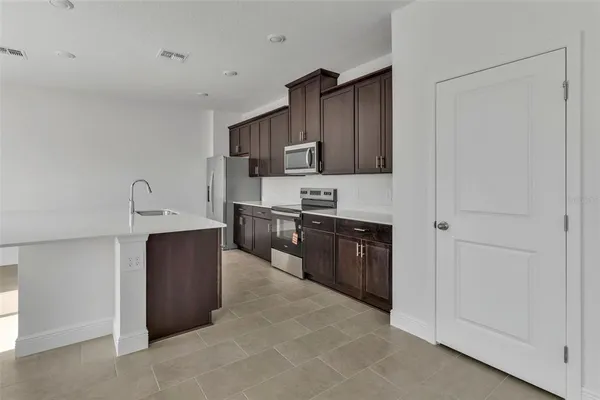 a kitchen with granite countertop a refrigerator and a stove top oven