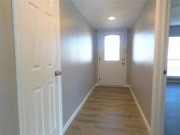 a view of a hallway with wooden floor and closet
