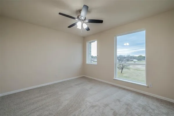 an empty room with windows and fan