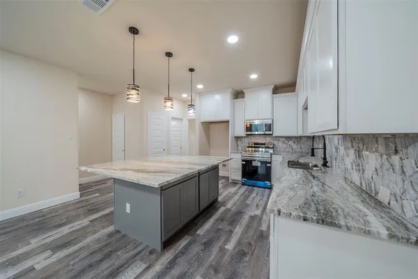 a kitchen with a stove sink and cabinets
