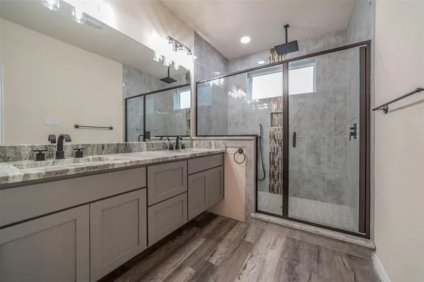 a bathroom with a shower sink and mirror