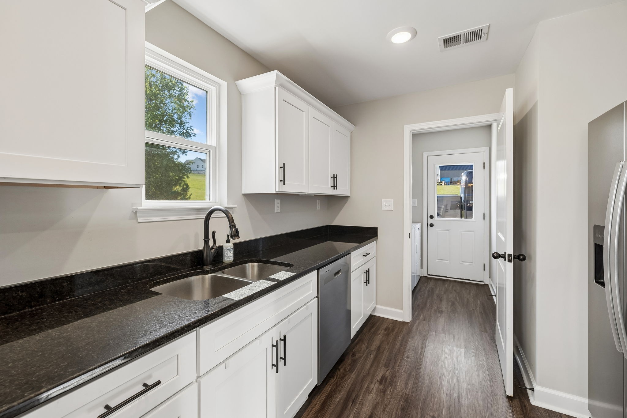 300 Still Point Road Smithville, TN 37166 - Photo 15 of 40 a kitchen with granite countertop a sink a window and cabinets