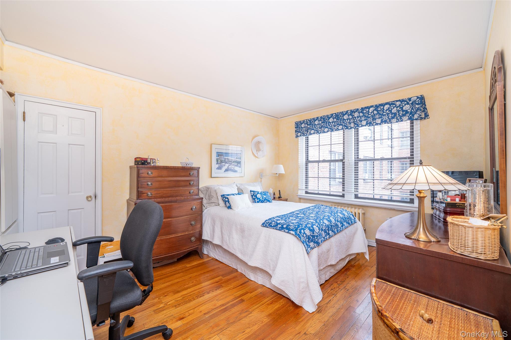 180 Garth Road, Unit 5F Scarsdale, NY 10583 - Photo 12 of 26 a bedroom with a bed and wooden floor