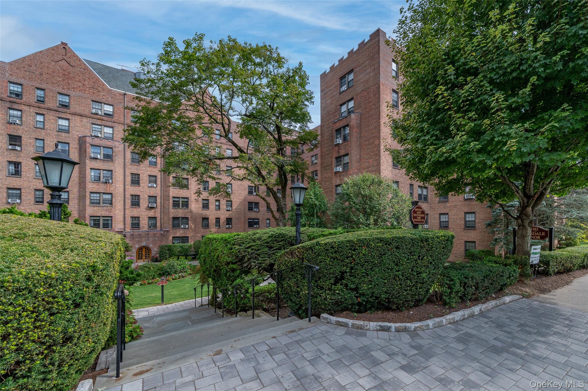 180 Garth Road, Unit 5F Scarsdale, NY 10583 - Photo 18 of 26 a view of a garden with a building in the background