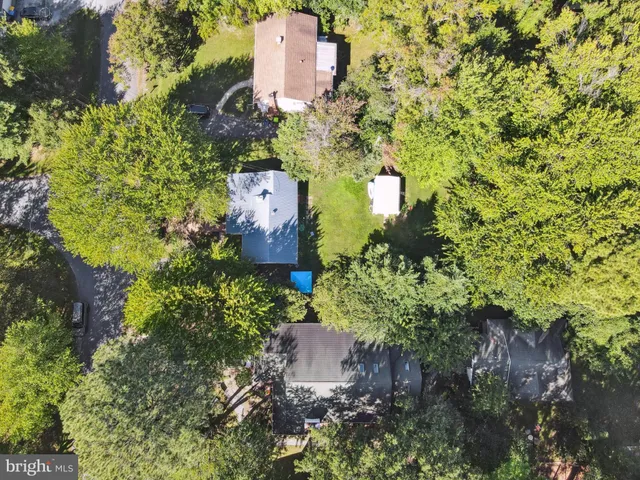 an aerial view of a house with a yard and trees