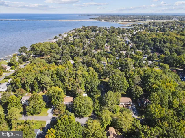 an aerial view of a house with a yard and lake view
