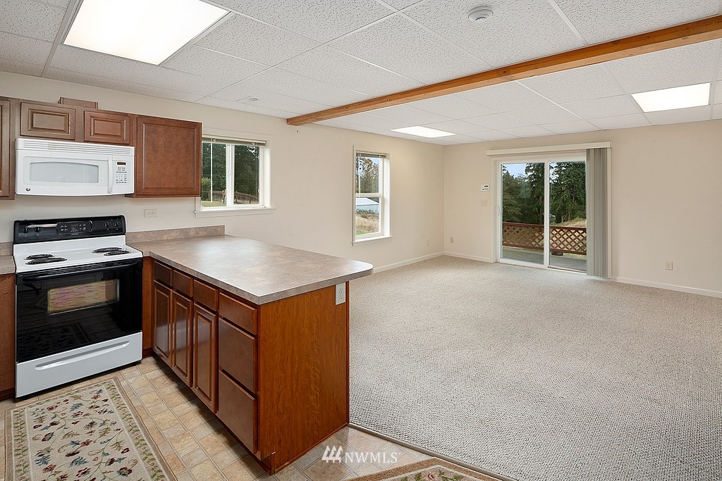 2075 East Goss Lake Road Freeland, WA 98249 - Photo 19 of 40 a kitchen with granite countertop a stove and a sink