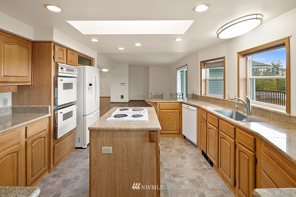 2075 East Goss Lake Road Freeland, WA 98249 - Photo 6 of 40 a kitchen with stainless steel appliances granite countertop a sink a stove and a refrigerator