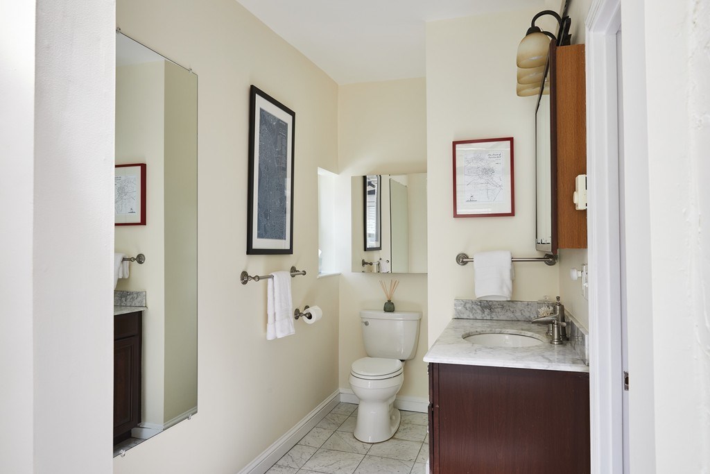 1920 Washington Street, Unit 6 Boston, MA 02118 - Photo 9 of 15 a bathroom with a granite countertop toilet sink and mirror