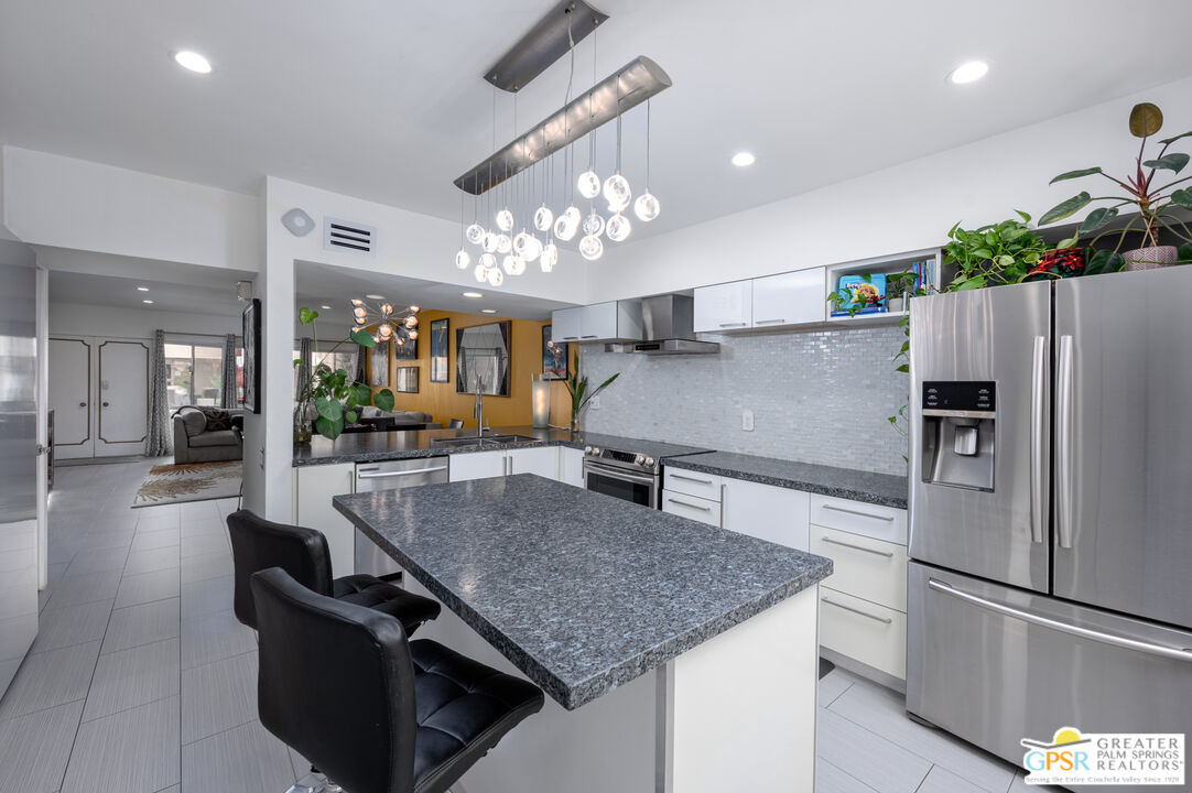 277 East Alejo Road, Unit 124 Palm Springs, CA 92262 - Photo 11 of 25 a kitchen with kitchen island a counter top space appliances and cabinets