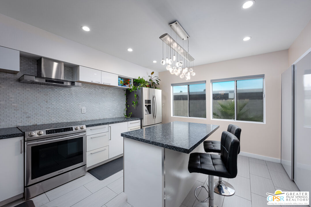 277 East Alejo Road, Unit 124 Palm Springs, CA 92262 - Photo 12 of 25 a kitchen with stainless steel appliances granite countertop a stove and a sink with granite countertops