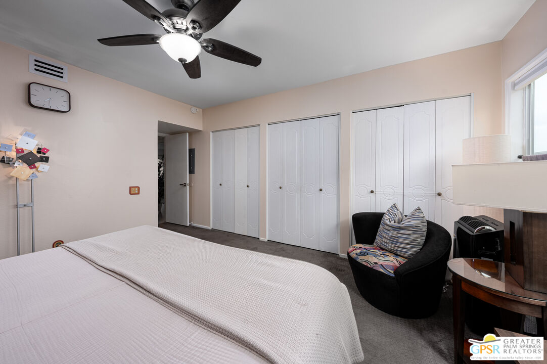 277 East Alejo Road, Unit 124 Palm Springs, CA 92262 - Photo 15 of 25 a bedroom with a bed and ceiling fan