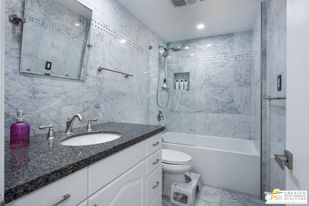 277 East Alejo Road, Unit 124 Palm Springs, CA 92262 - Photo 19 of 25 a bathroom with a granite countertop sink a toilet and shower