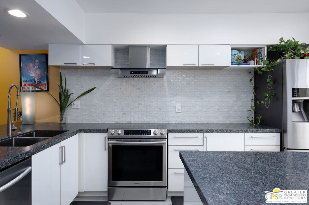 277 East Alejo Road, Unit 124 Palm Springs, CA 92262 - Photo 10 of 25 a kitchen with stainless steel appliances granite countertop a stove and a sink