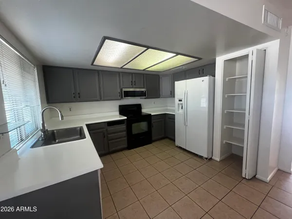 a kitchen with stainless steel appliances a refrigerator sink and microwave