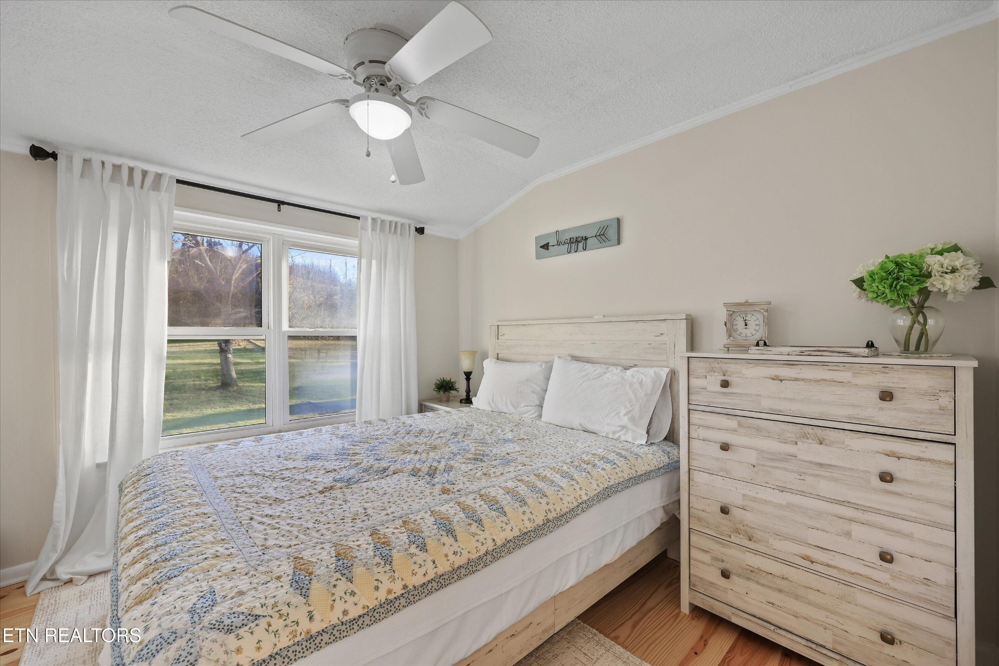 7969 Glendale Community Road Greenback, TN 37742 - Photo 35 of 56 a bedroom with a bed a chandelier and a large window