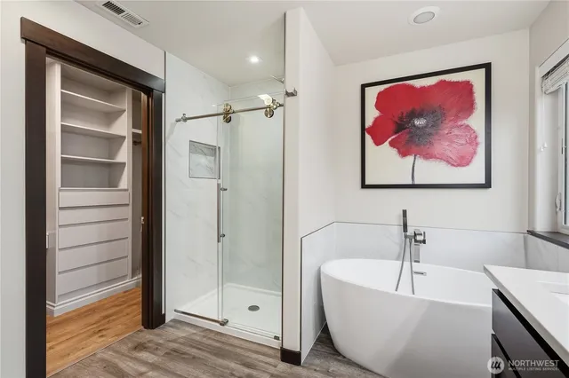 a view of a bathroom from a hallway with wooden floor
