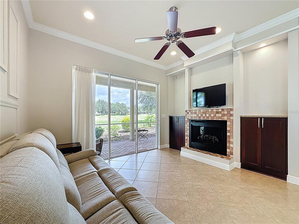 243 Bayou Bend Road Groveland, FL 34736 - Photo 16 of 77 a living room with furniture a flat screen tv and a fireplace