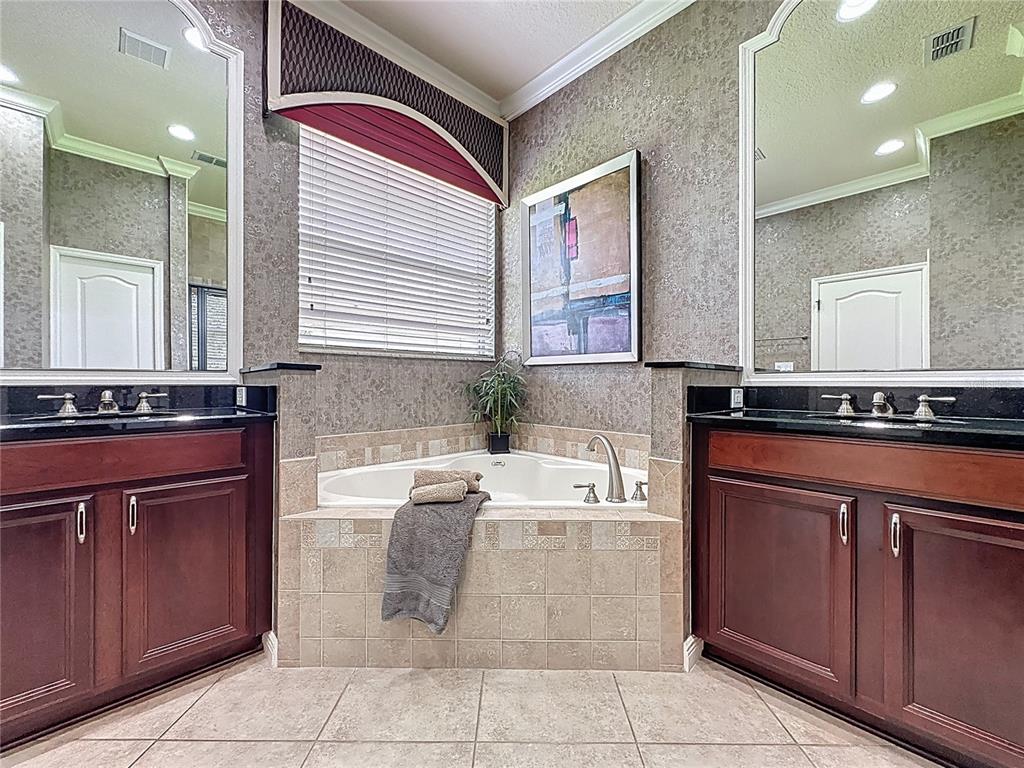 243 Bayou Bend Road Groveland, FL 34736 - Photo 26 of 77 a spacious bathroom with a granite countertop sink and a mirror