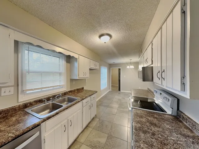 a kitchen with a sink stove and cabinets
