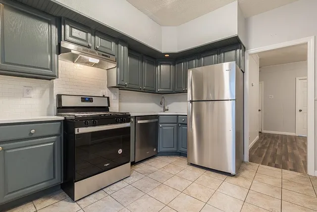a kitchen with a refrigerator sink and cabinets