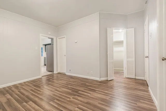 a view of an empty room with wooden floor