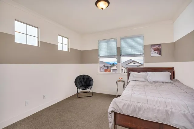 a spacious bedroom with a large bed and a chandelier