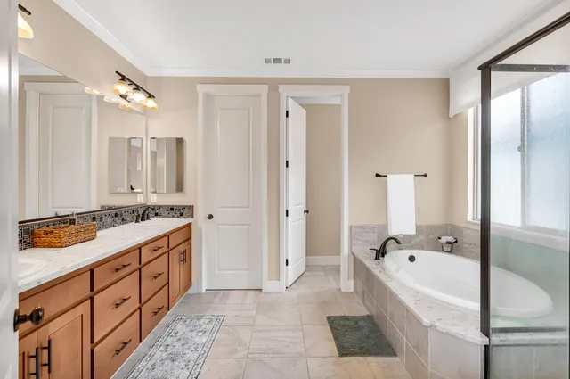 an aerial view of ocean and residential houses with outdoor space