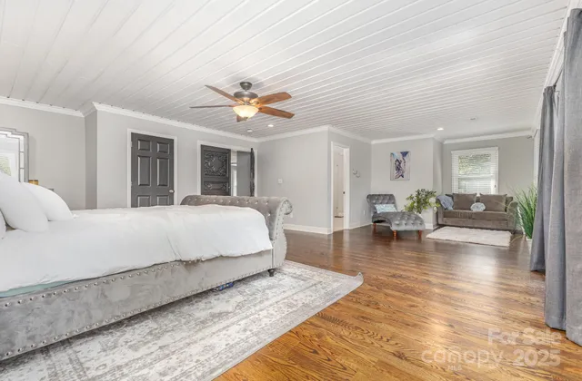 a spacious bedroom with a bed a table and a potted plant