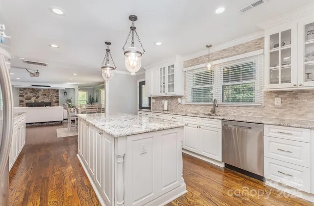 a kitchen with granite countertop kitchen island white cabinets and sink