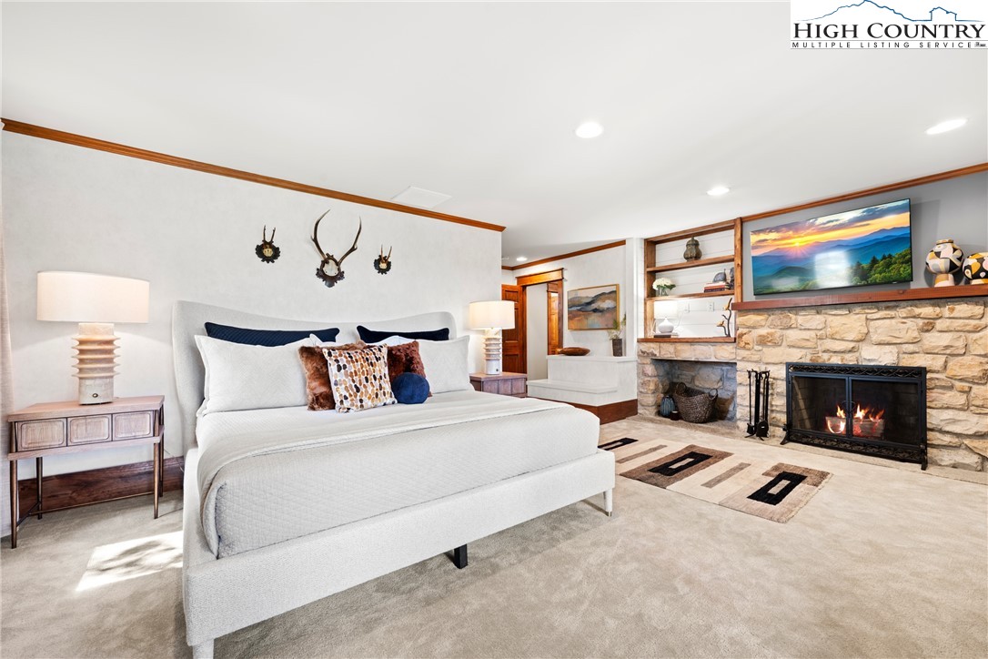 299 Edgewood Path Blowing Rock, NC 28605 - Photo 11 of 39 a spacious bedroom with a bed and a fireplace