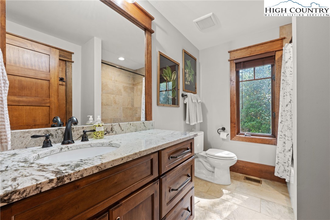 299 Edgewood Path Blowing Rock, NC 28605 - Photo 18 of 39 a bathroom with a granite countertop sink and a large mirror