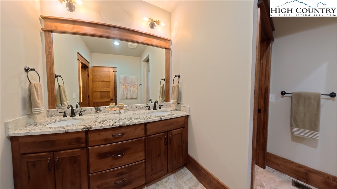 299 Edgewood Path Blowing Rock, NC 28605 - Photo 21 of 39 a bathroom with a double vanity sink and mirror